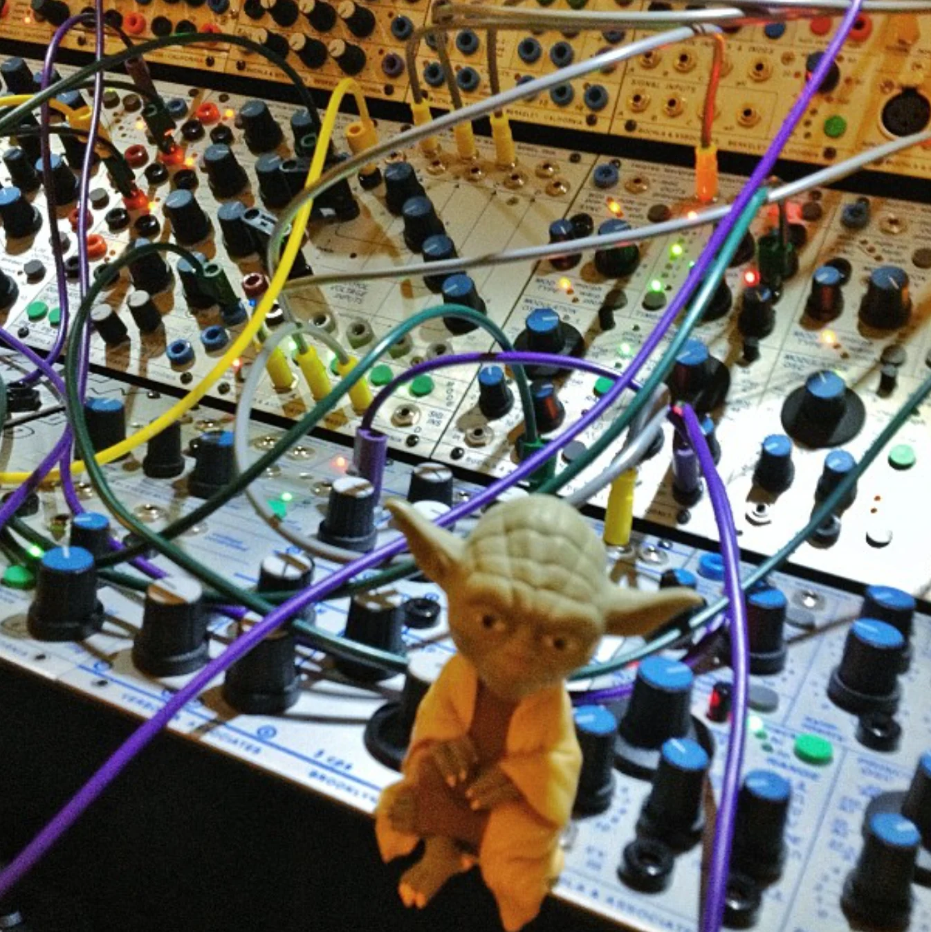 A close view of patch cables and modules, with a small Yoda figure.