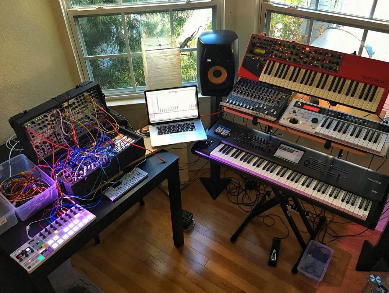 Ron’s studio with a patched modular rack, keyboards, and monitoring setup.